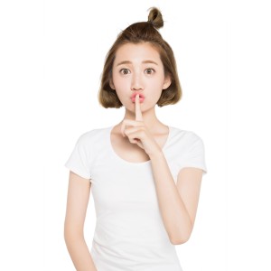 Woman holding a finger against her mouth